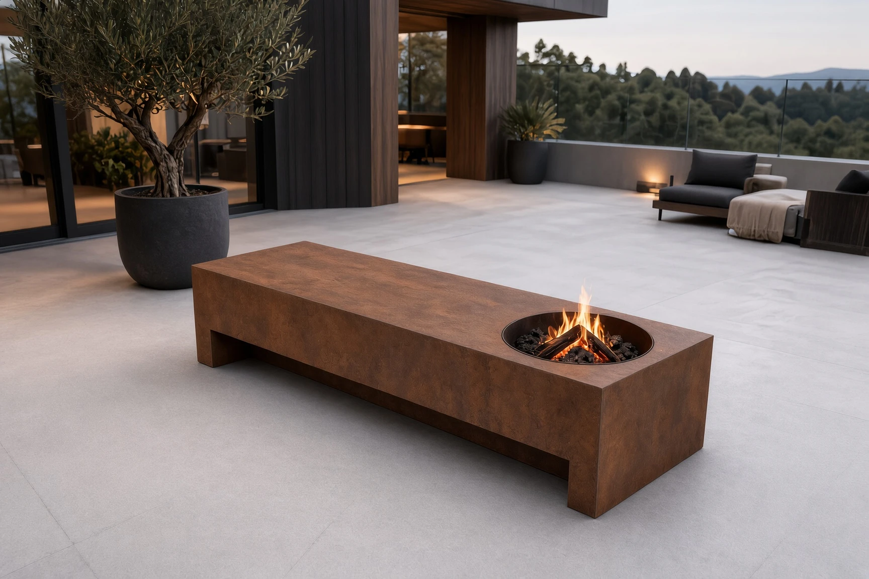 Table de feu Taranis en acier Corten allumée sur une grande terrasse dallée, vue plongeante de trois quarts