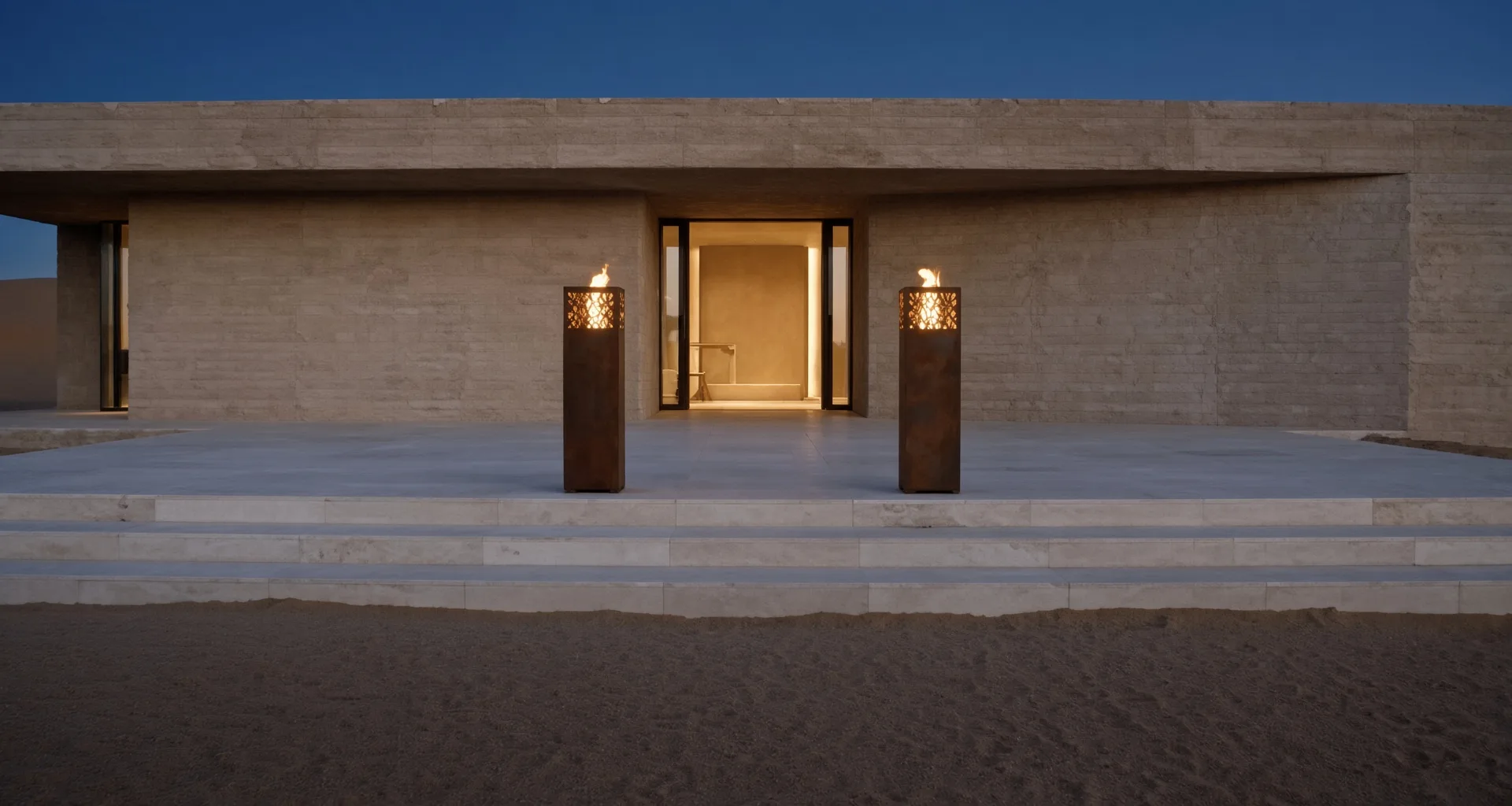 Deux lanternes Vesper en acier Corten encadrant l'entrée d'une maison en pierre, vue large au crépuscule