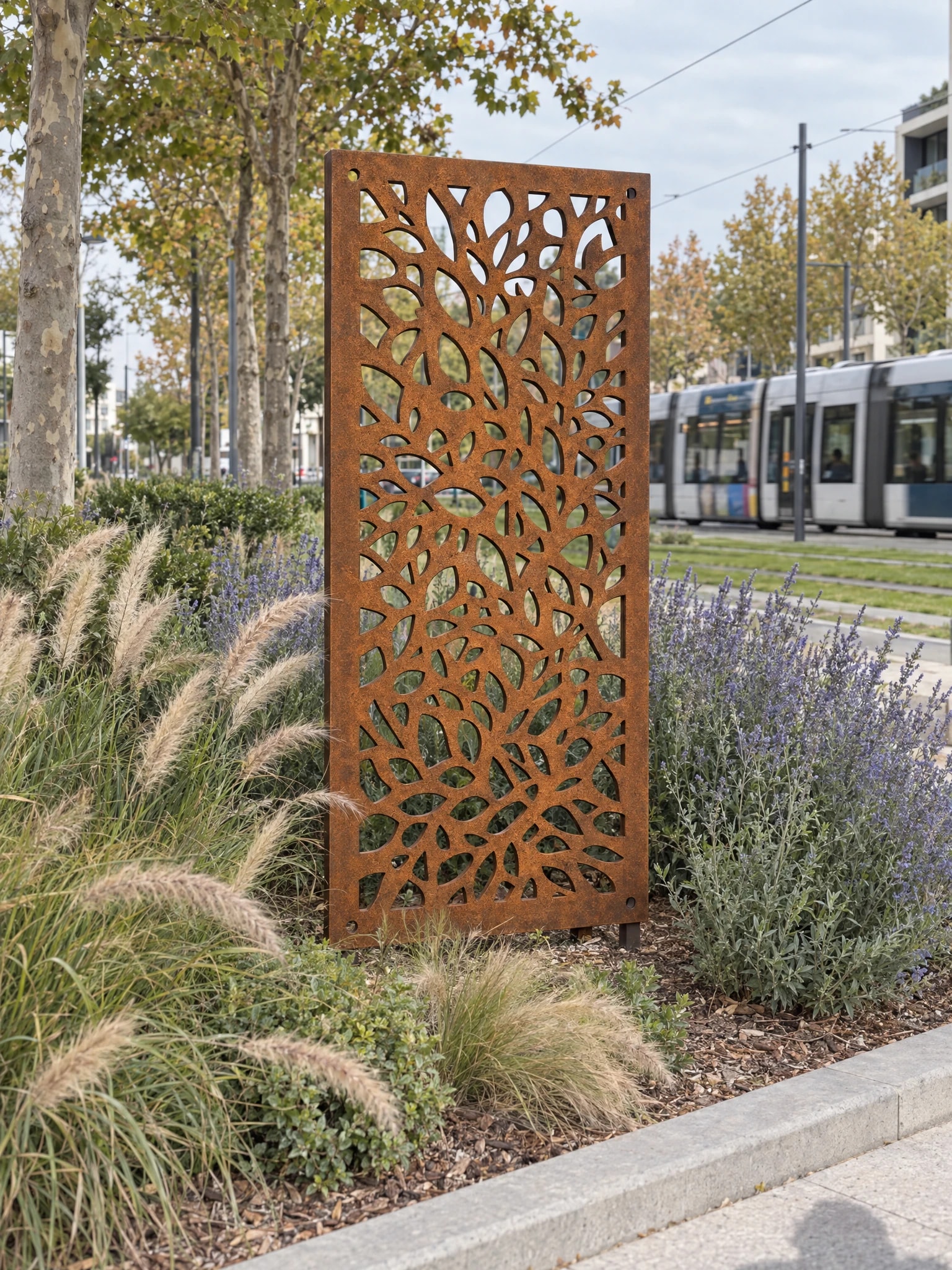 Panneau décoratif Mistral en acier Corten dans un massif de graminées et de lavandes, le long d'une voie de tramway