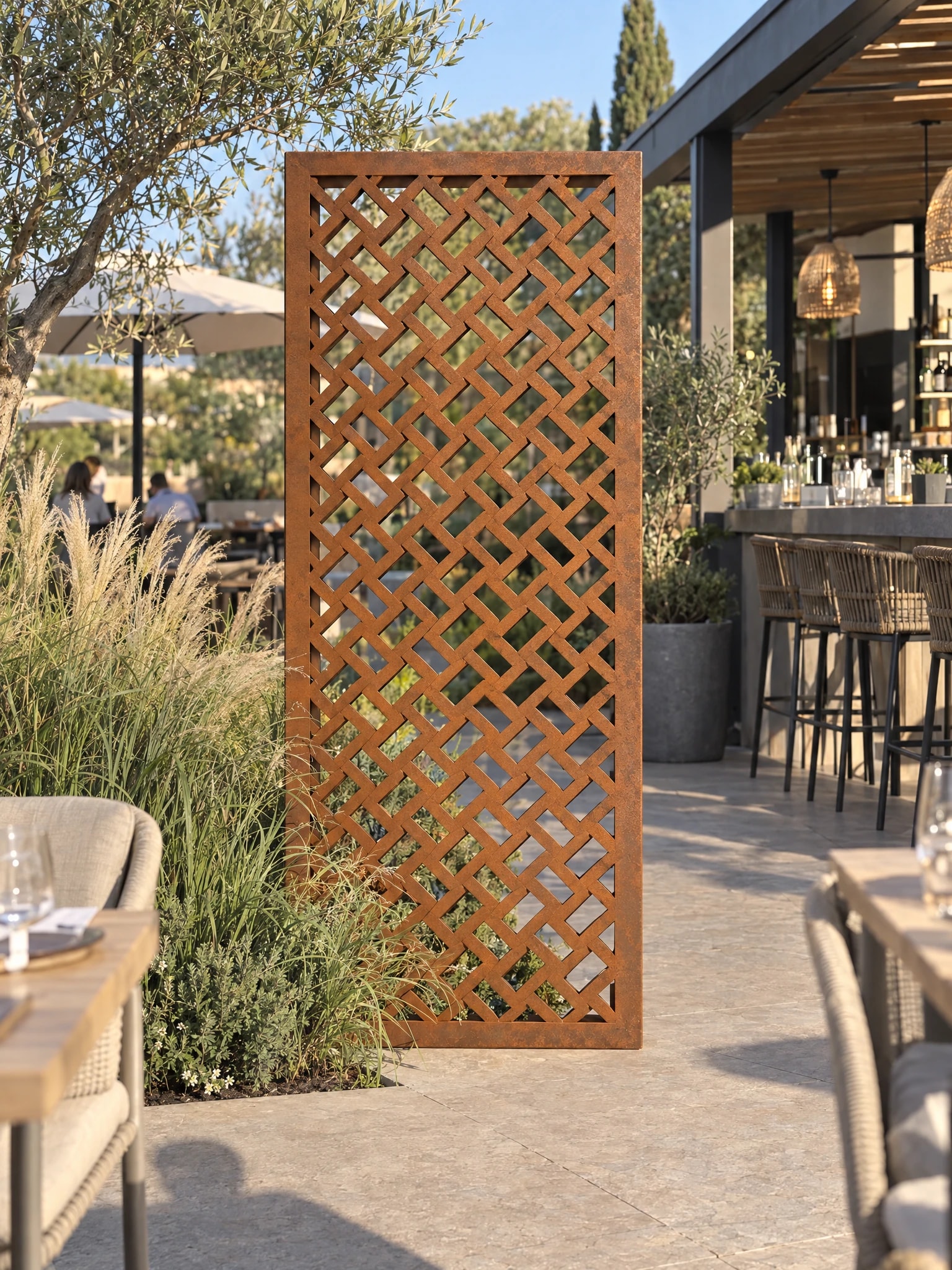 Panneau décoratif Ponant en acier Corten dressé sur une terrasse de restaurant, bar et tables dressées autour
